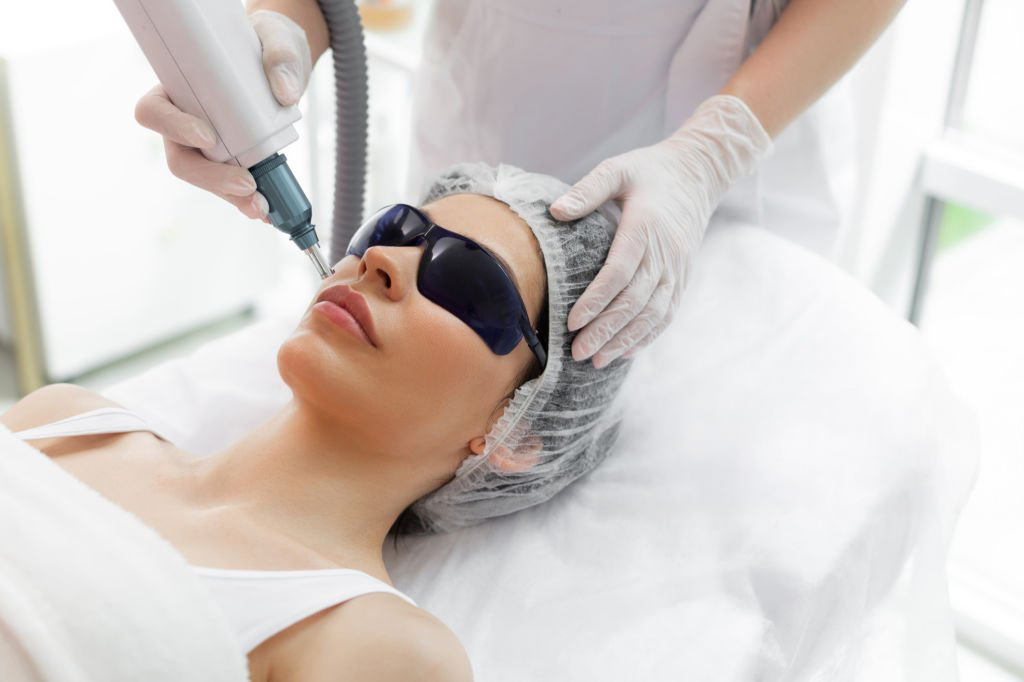 Latest innovations. Nice pretty woman receiving laser skin treatment while visiting a beautician