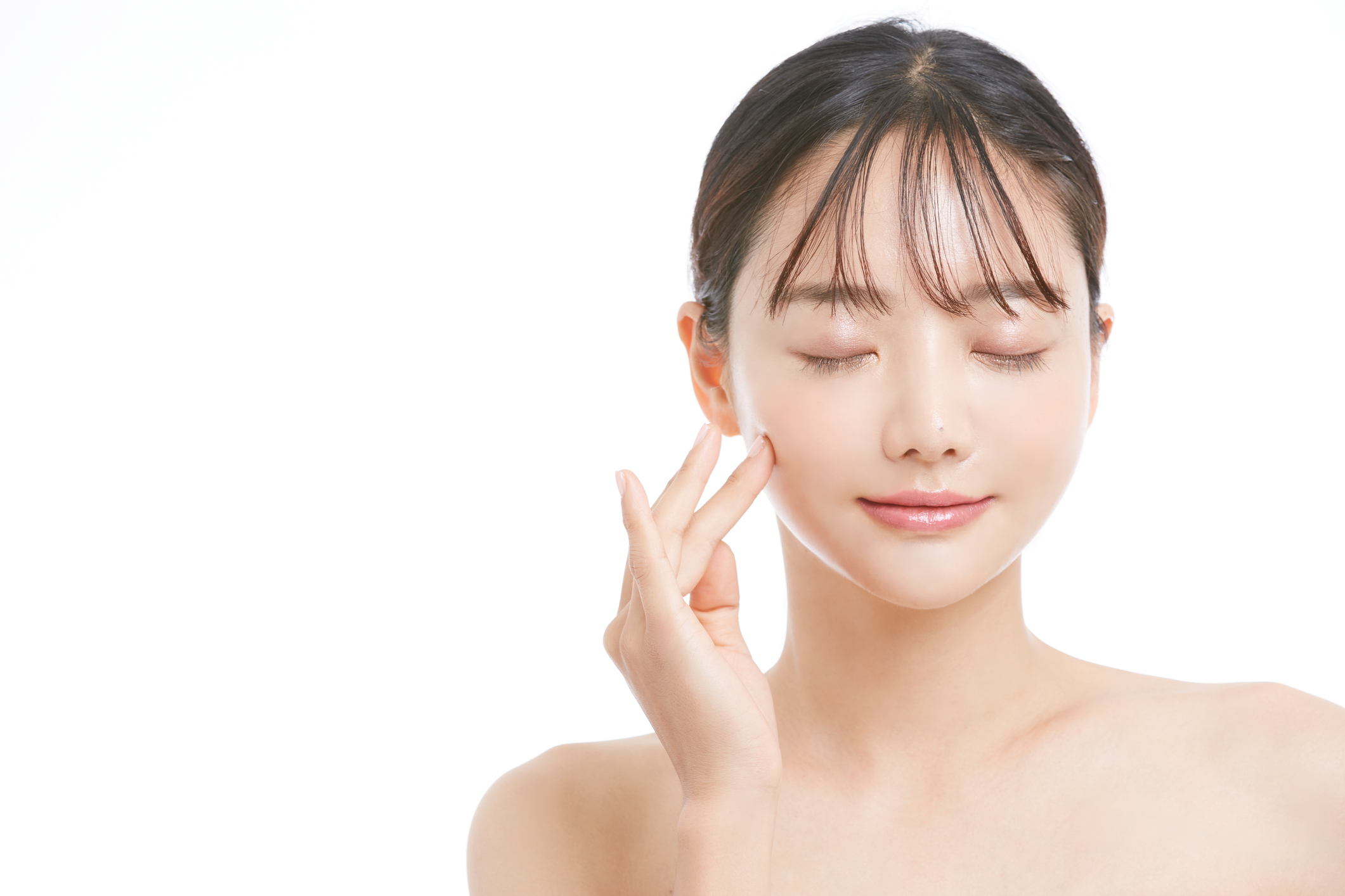Woman gently touching her face with eyes closed, symbolizing relaxation and skin confidence—illustrating the benefits of combining energy devices and injectables.