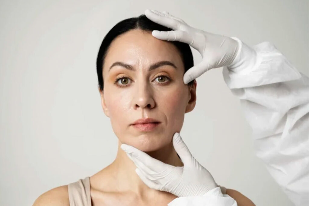Doctor examining a woman’s face for cosmetic surgery or facelift evaluation.