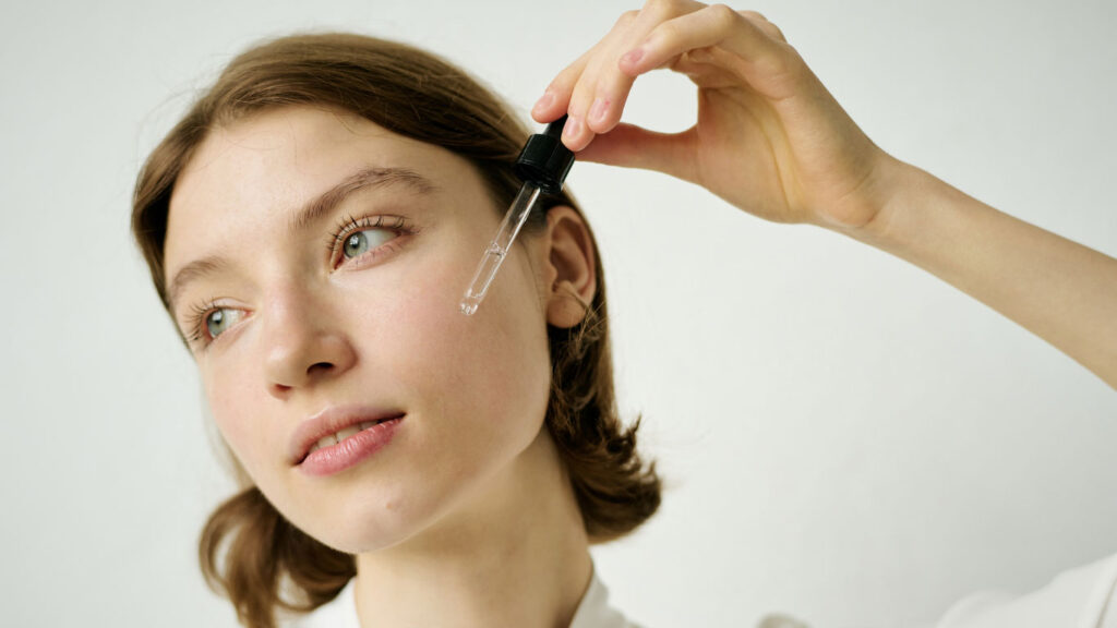 A person applying serum/sunscreen to highlight the necessity of strict photoprotection during pigmentation recovery.