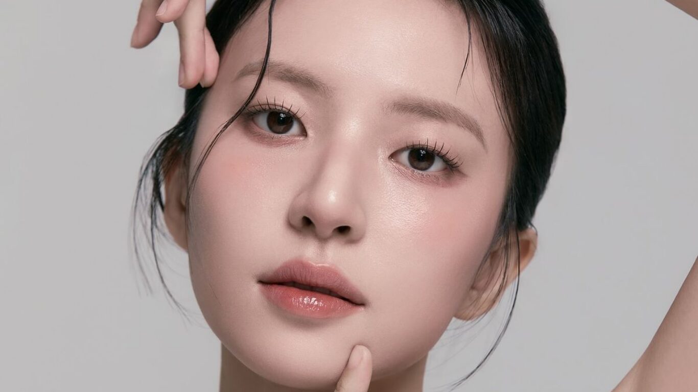 Close-up of a woman with a clear, refreshed complexion lightly touching her jawline