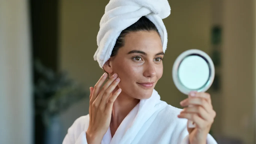 Woman looking at her face in the mirror